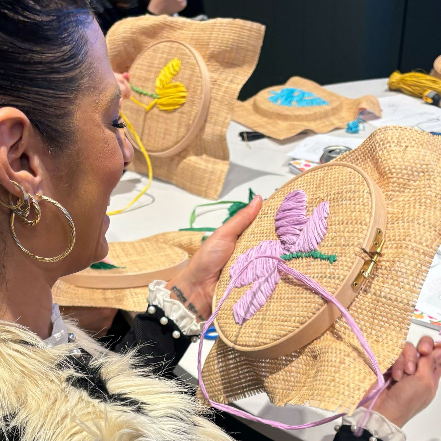 Image of someone at a previous raffia embroidery workshop working on their project